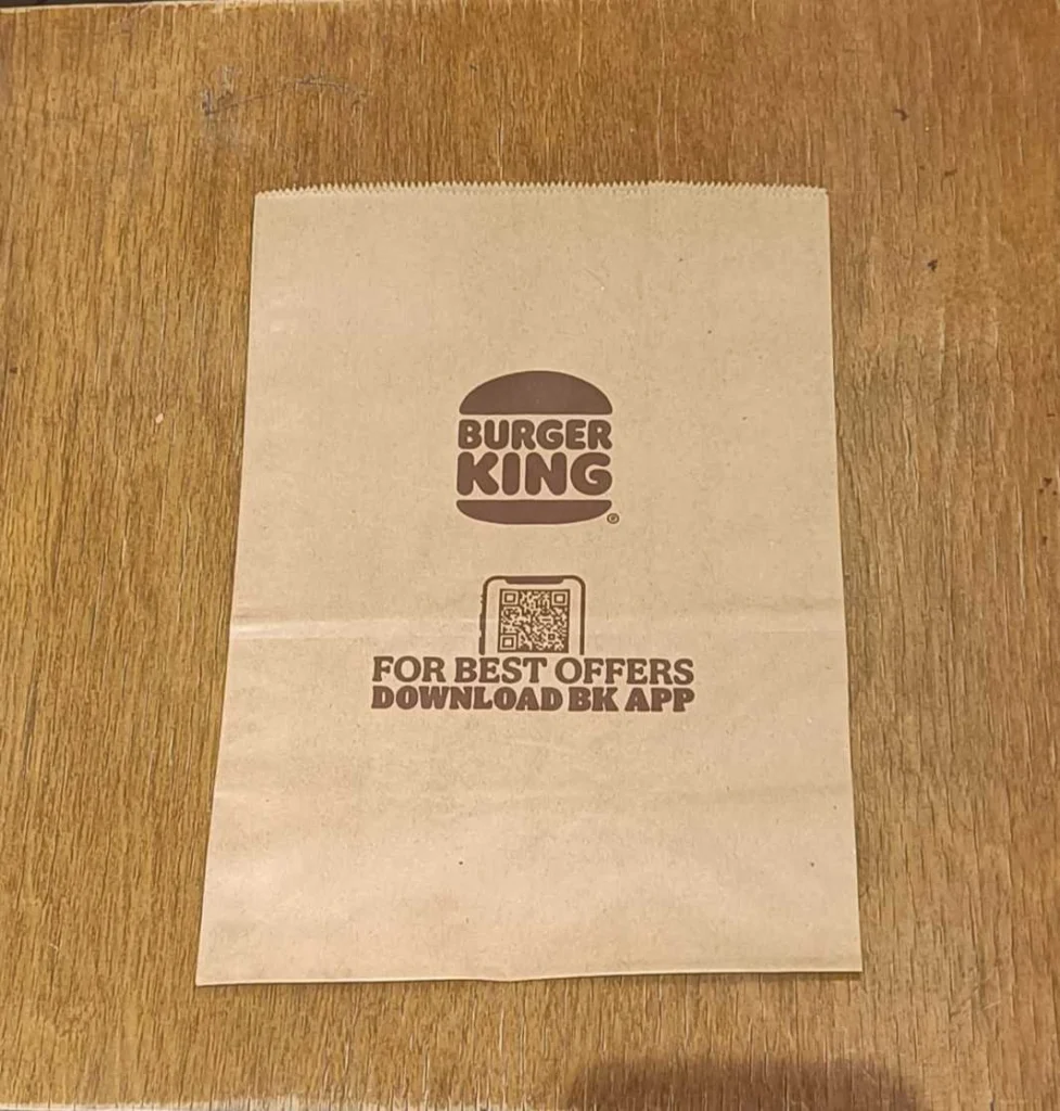 A transparent QR Code on Burger King delivery packet asking users to download their mobile app to directly order from it.