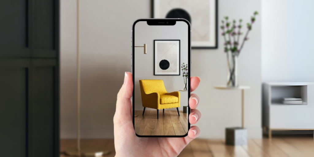 A hand holding a smartphone checking how a sofa will look in the room through augmented reality.