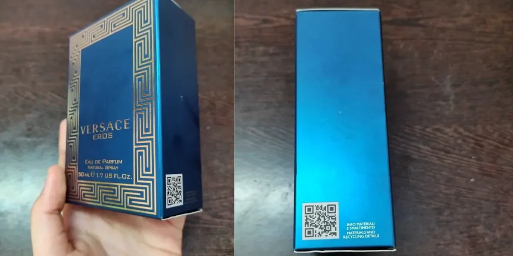 A hand holding Versace perfume in blue packaging with a QR code to promote sustainability.