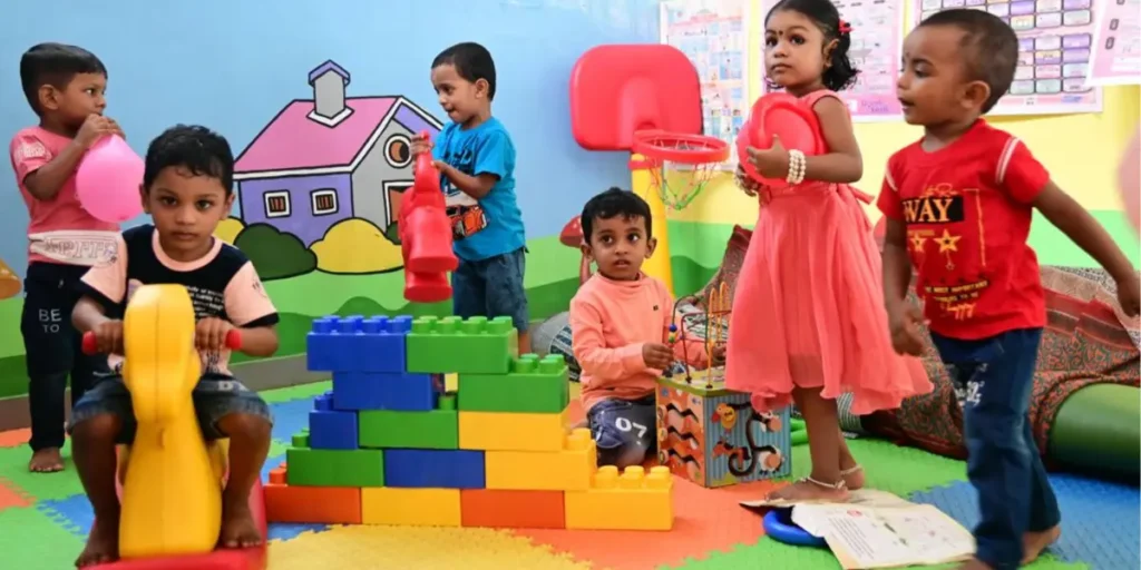 An image of students of age group of 3-4 year old playing in a school and accessing stories and songs through digital access (QR Codes)