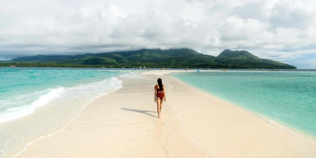 a woman walking by the Camiguin beach, located in the Phillipines, Asia