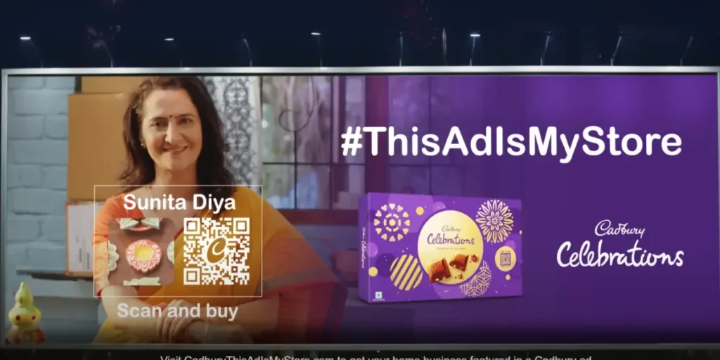 A billboard for a Cadbury celebration. It has a transparent QR Code and a logo in the center. A lady promoting her Diya collection with a CTA - scan and buy.  