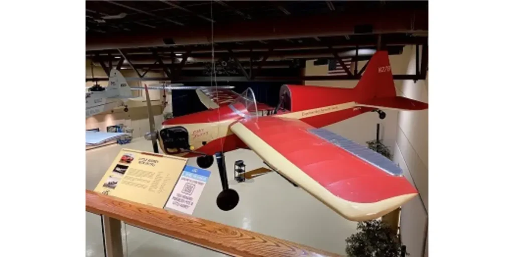 Display of a red aircraft in an Oshkosh museum with a QR code for more information.