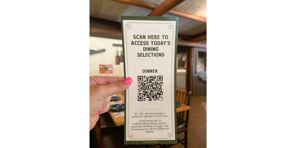 A woman holding a Disney restaurant QR Code receipt.