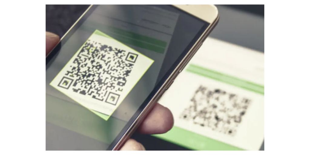 A hand holding a smartphone scanning a QR Code in Japan.