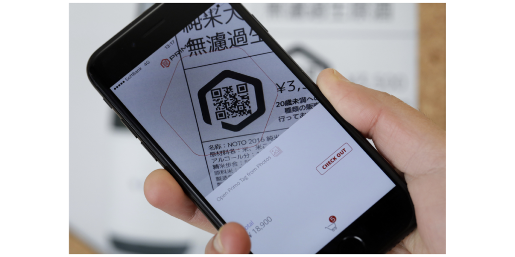 A hand holding a smartphone scanning a QR Code.